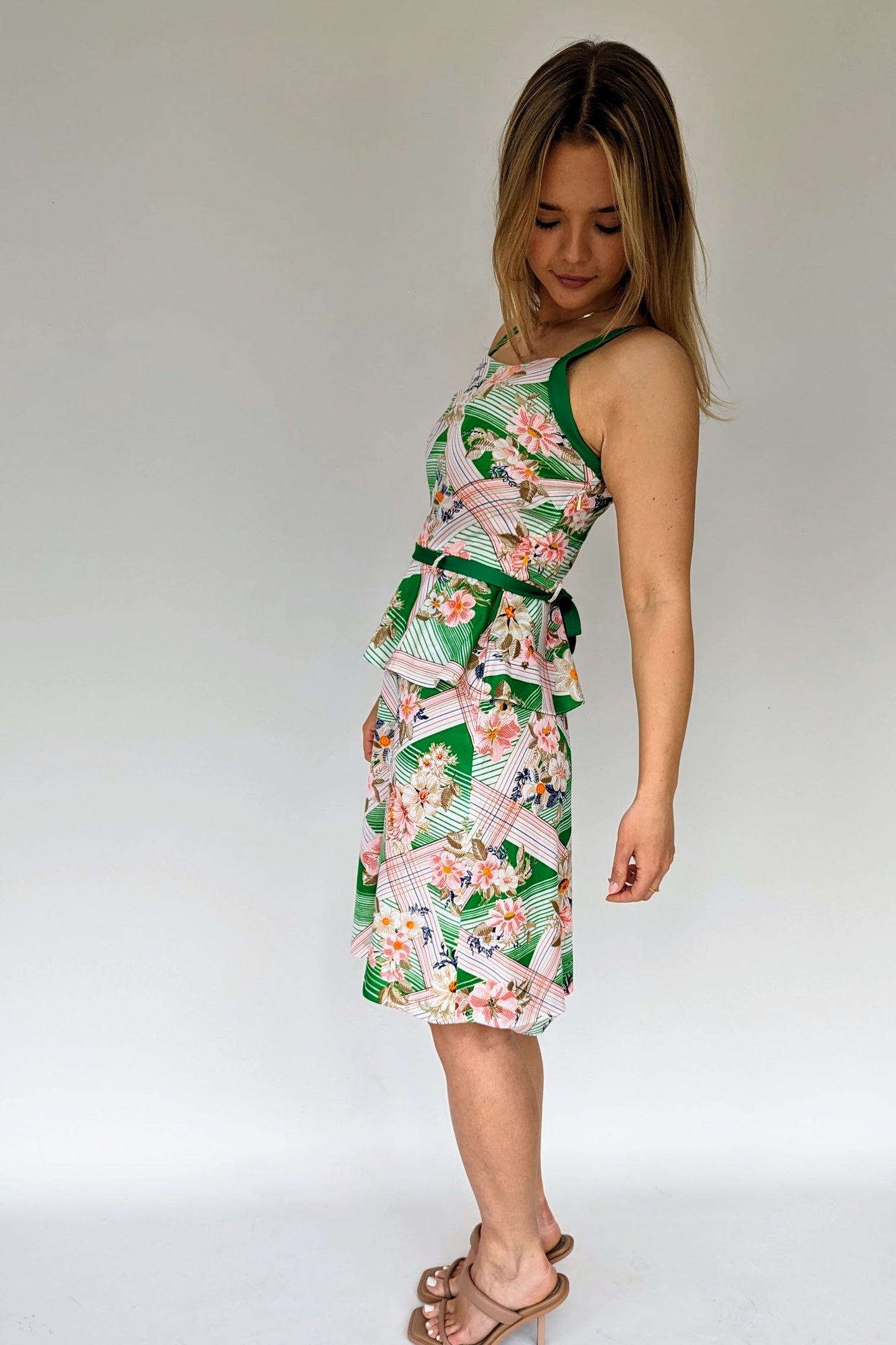 side of vintage tropical patterned peplum dress with green belt in white, green and pink