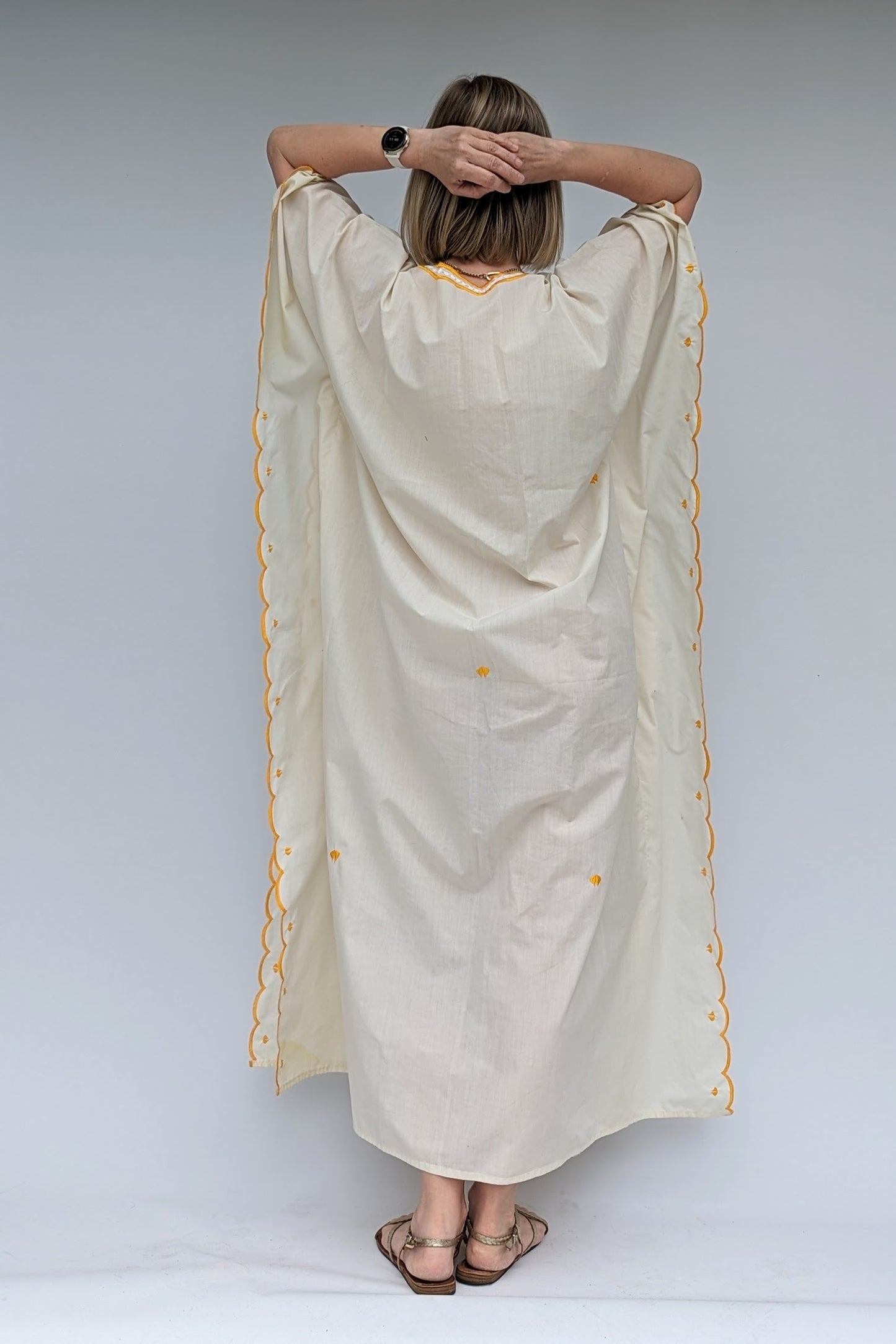 back view of vintage cream kaftan with embroidered flowers in yellow, green, pink and lilac