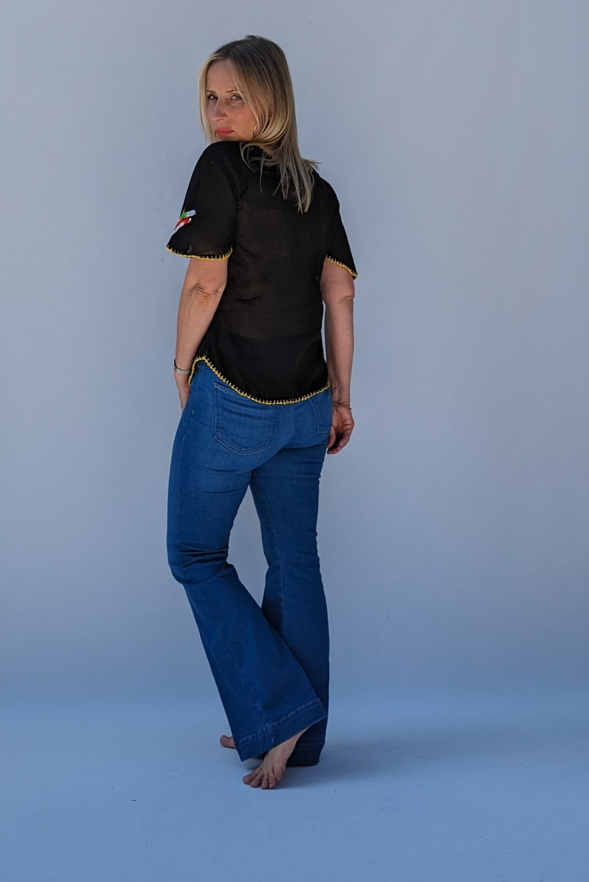 back of Black embroidered vintage mexican blouse in yellow, blue, red and green