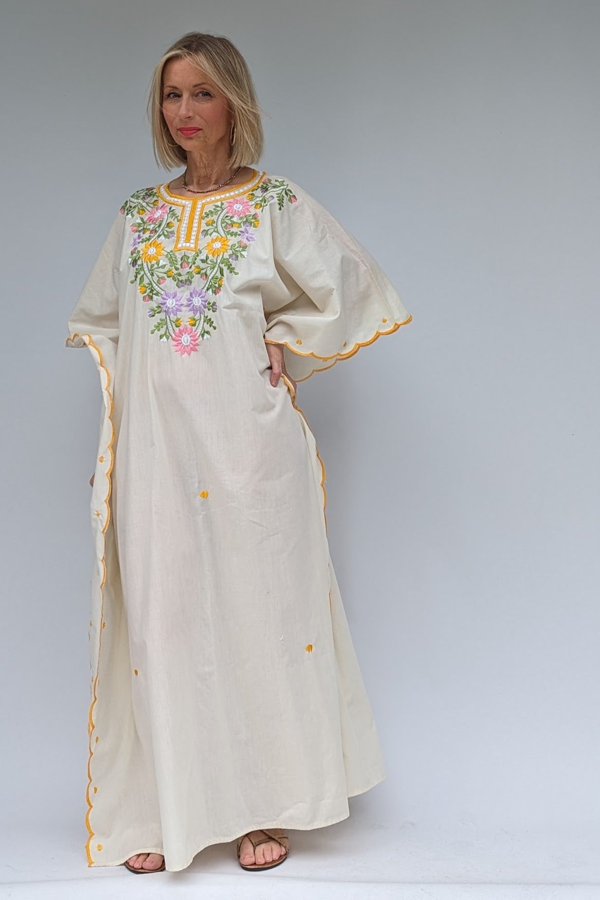 front view of vintage cream kaftan with embroidered flowers in yellow, green, pink and lilac