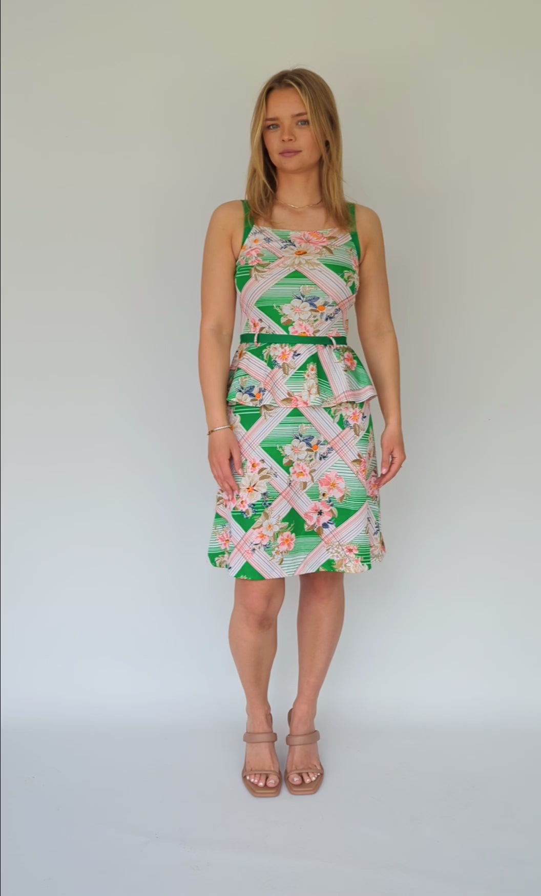 video clip of tropical patterned peplum dress with green belt in white, green and pink