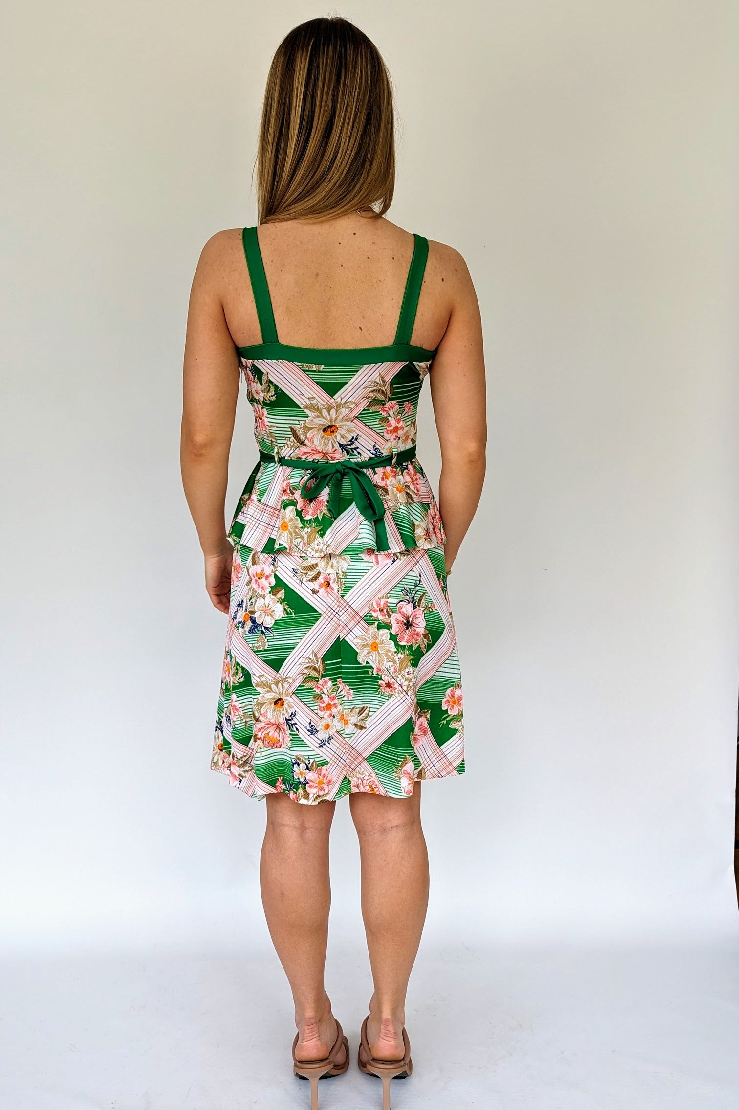 back of vintage tropical patterned peplum dress with green belt in white, green and pink