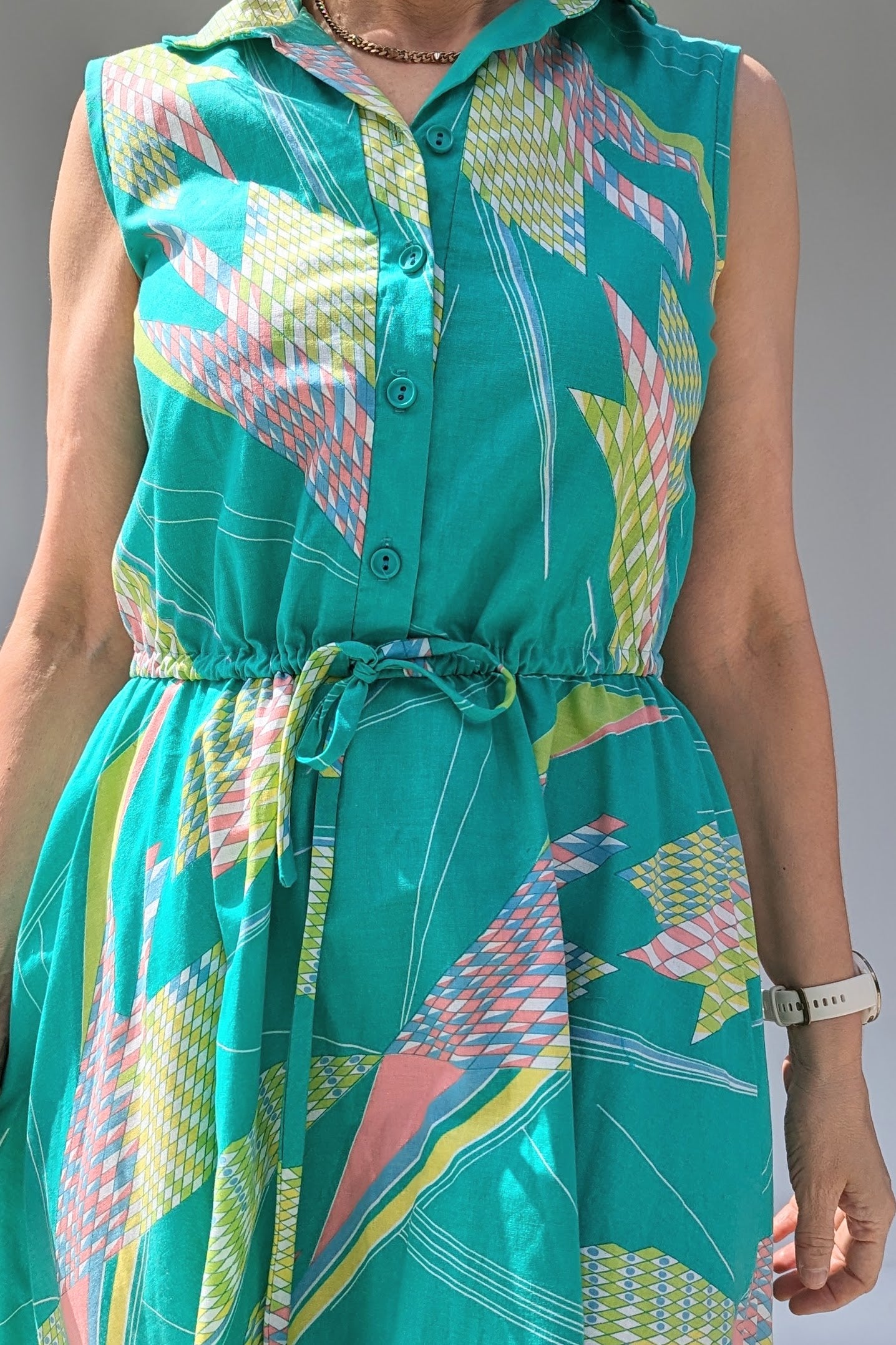close up of Vintage cotton summer tea dress in turquoise with a geometric pattern in pastels