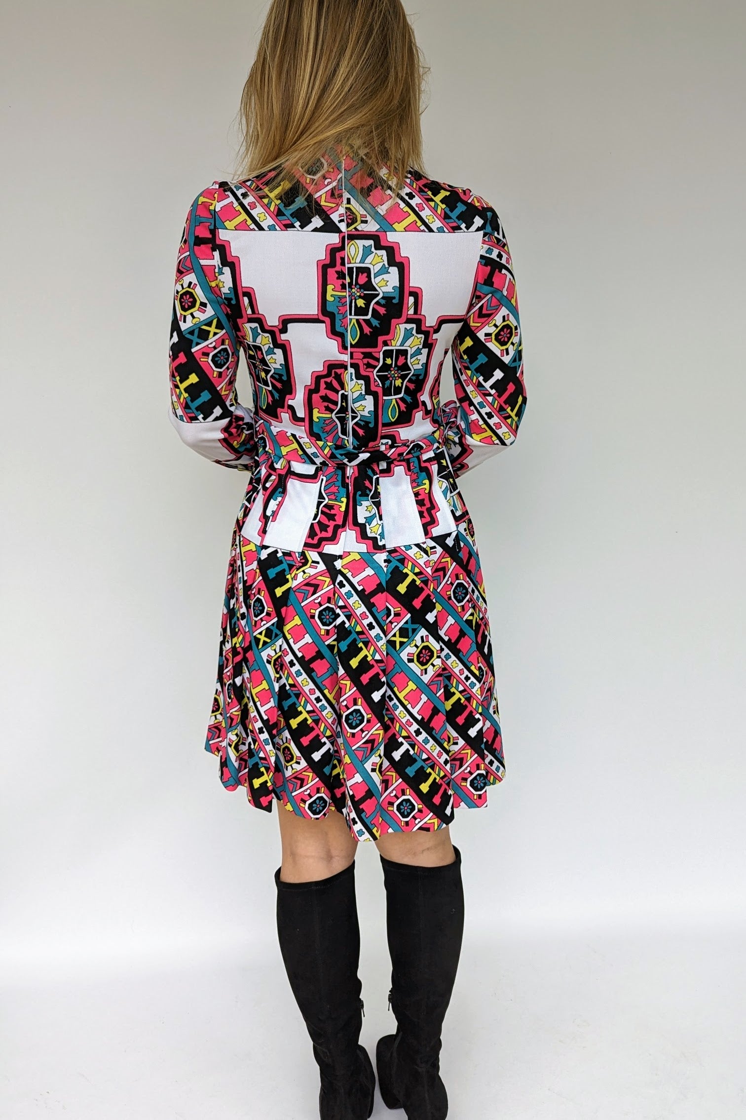 back of vintage 1970s patterned dress with belt and pleats in what, black, pink and turquoise geometrics pattern