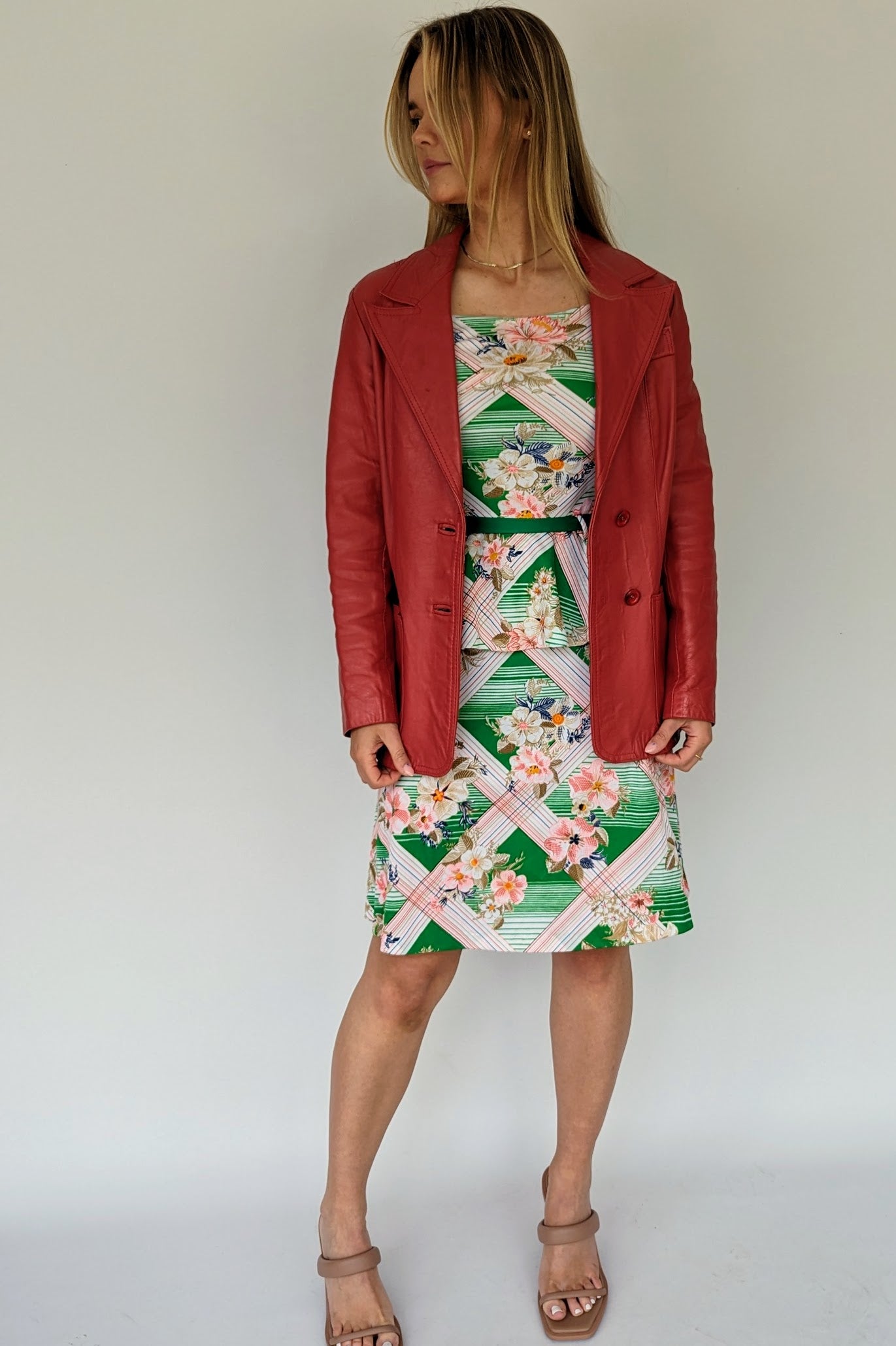 vintage tropical patterned peplum dress with green belt in white, green and pink with red leather jacket over