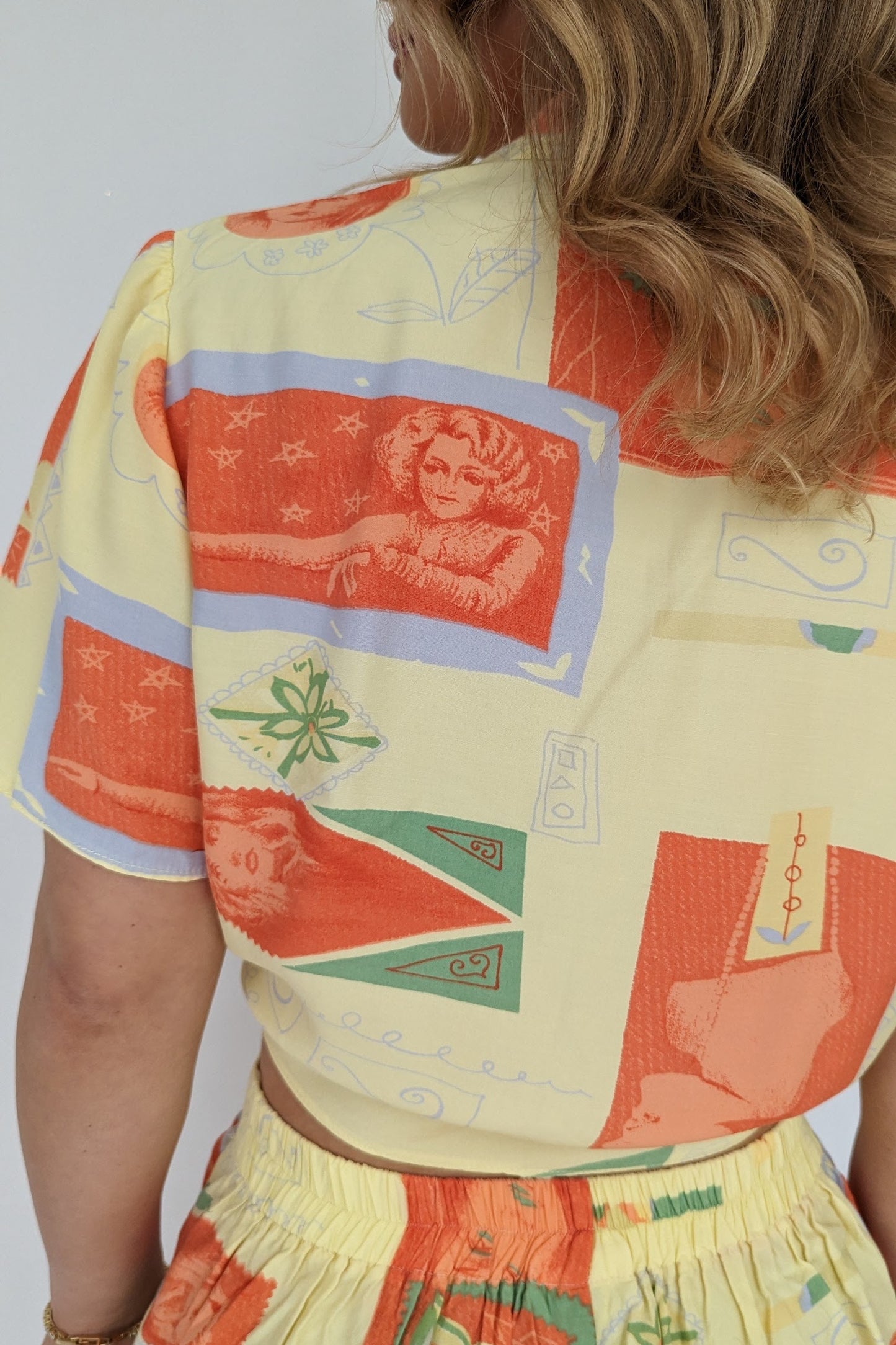 close up of material on back of vintage 80s yellow and orange co-ordinate set with shorts and a tie blouse