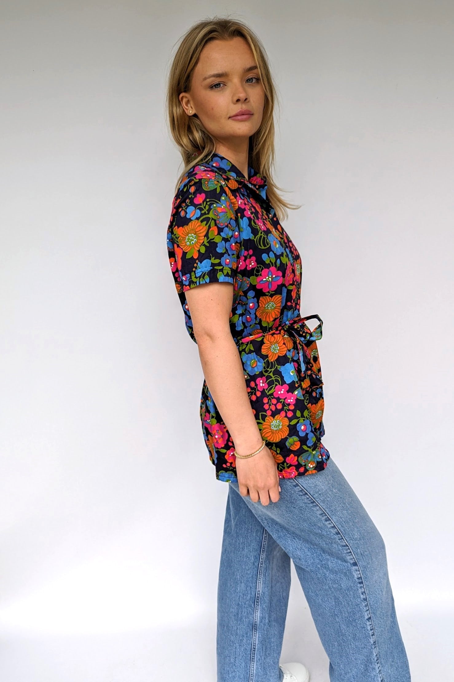 side view of bright floral summer vintage blouse with tie waist and dagger collar
