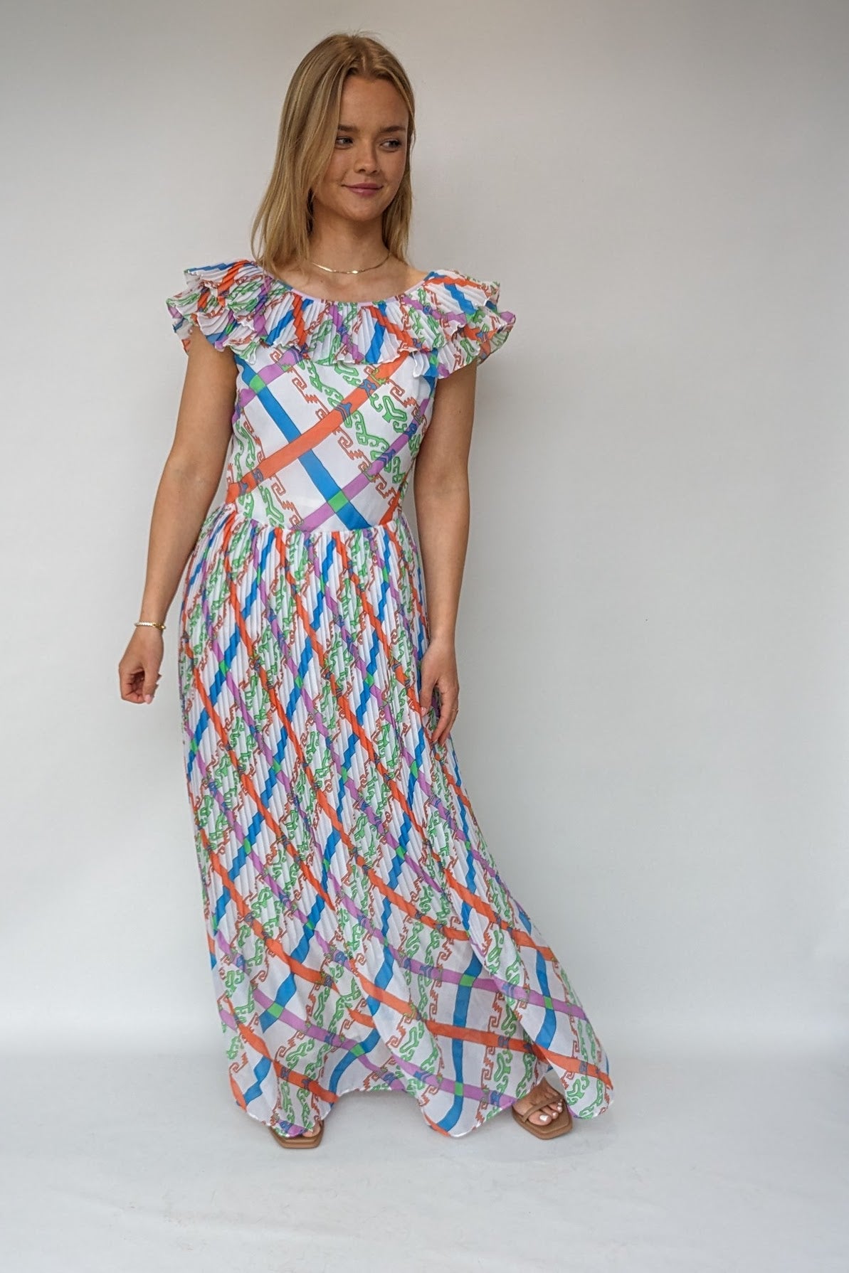 vintage 1970s maxi dress with bold pattern of orange, green, blue and purple with frill neckline