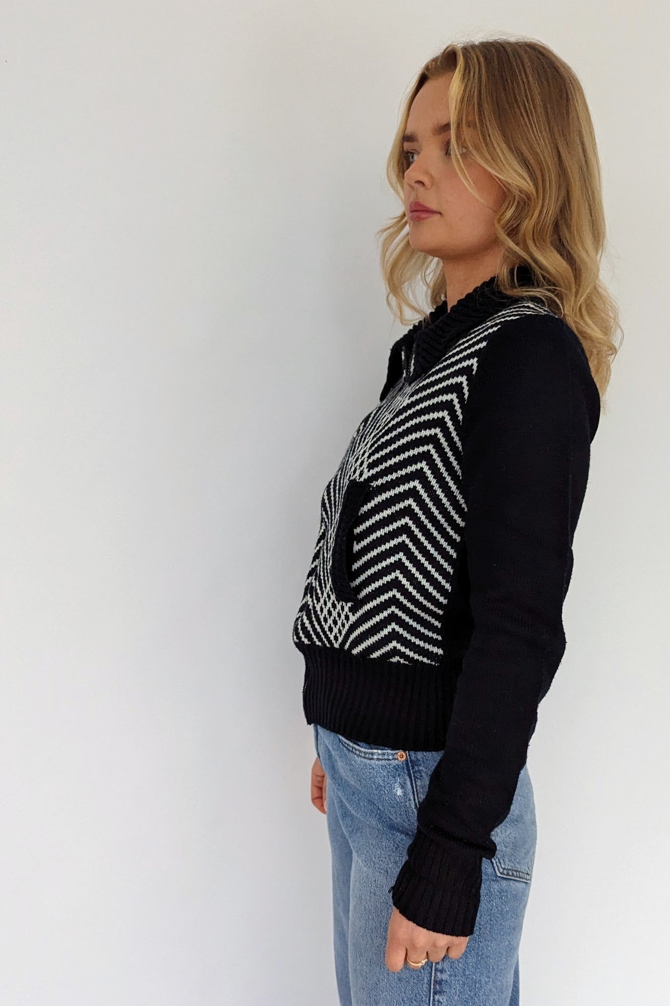 side of black and white short 60s cardigan with zip and pockets with geometrical pattern