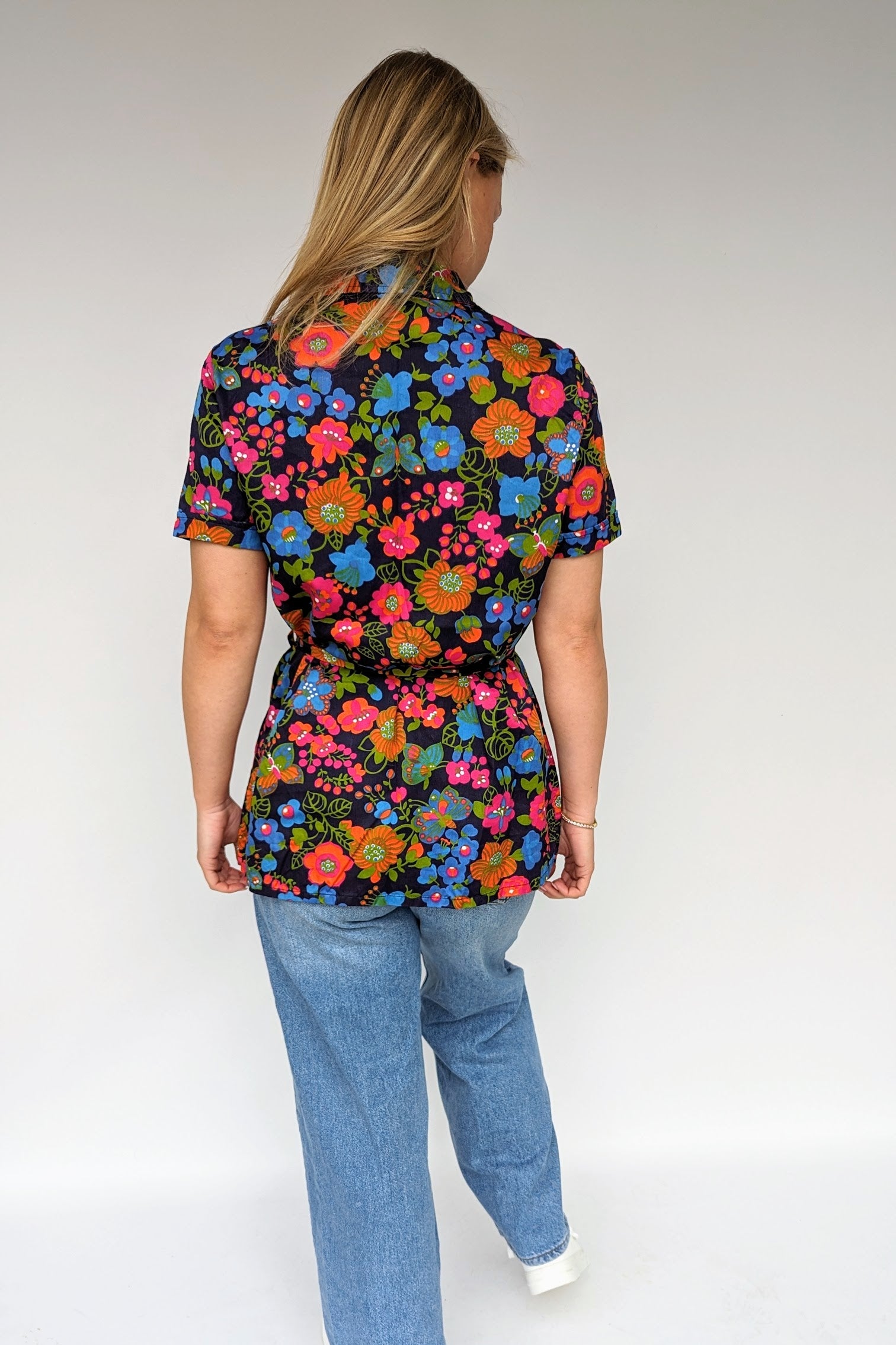 back view of bright floral summer vintage blouse with tie waist and dagger collar