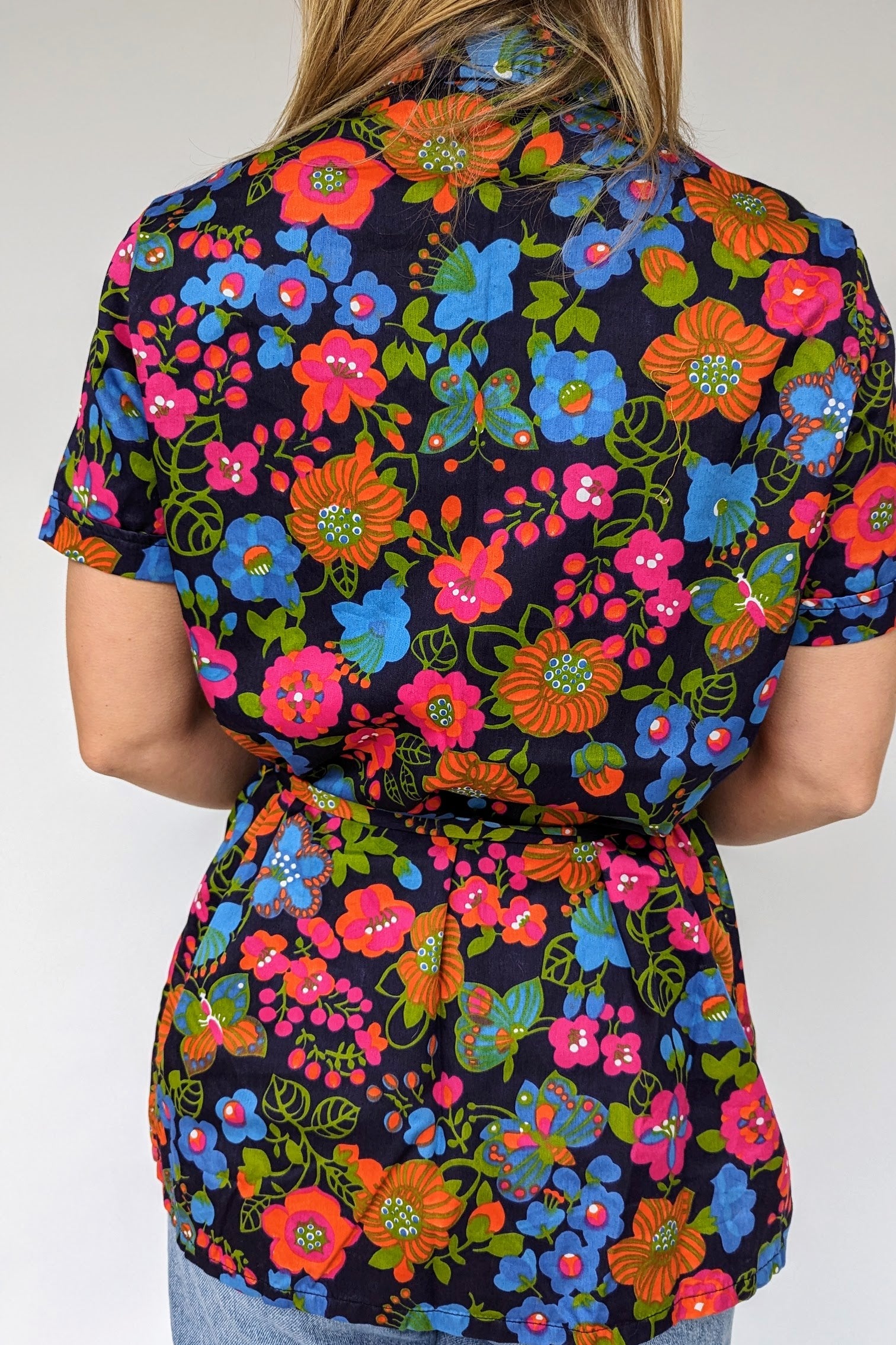 close up of back view bright floral summer vintage blouse with tie waist and dagger collar