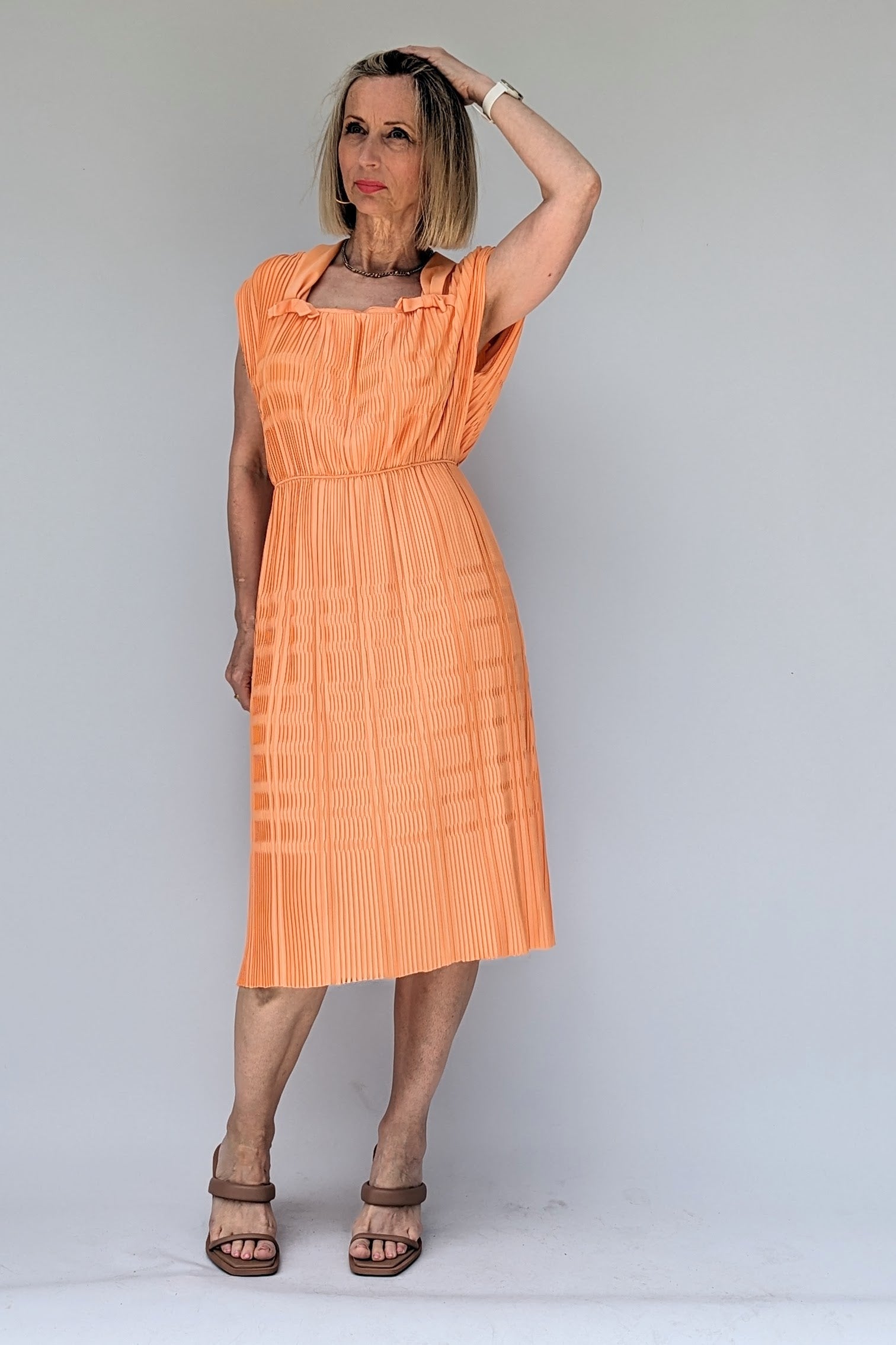 vintage pleated peach coloured midi dress from 1960s with square neck and bows