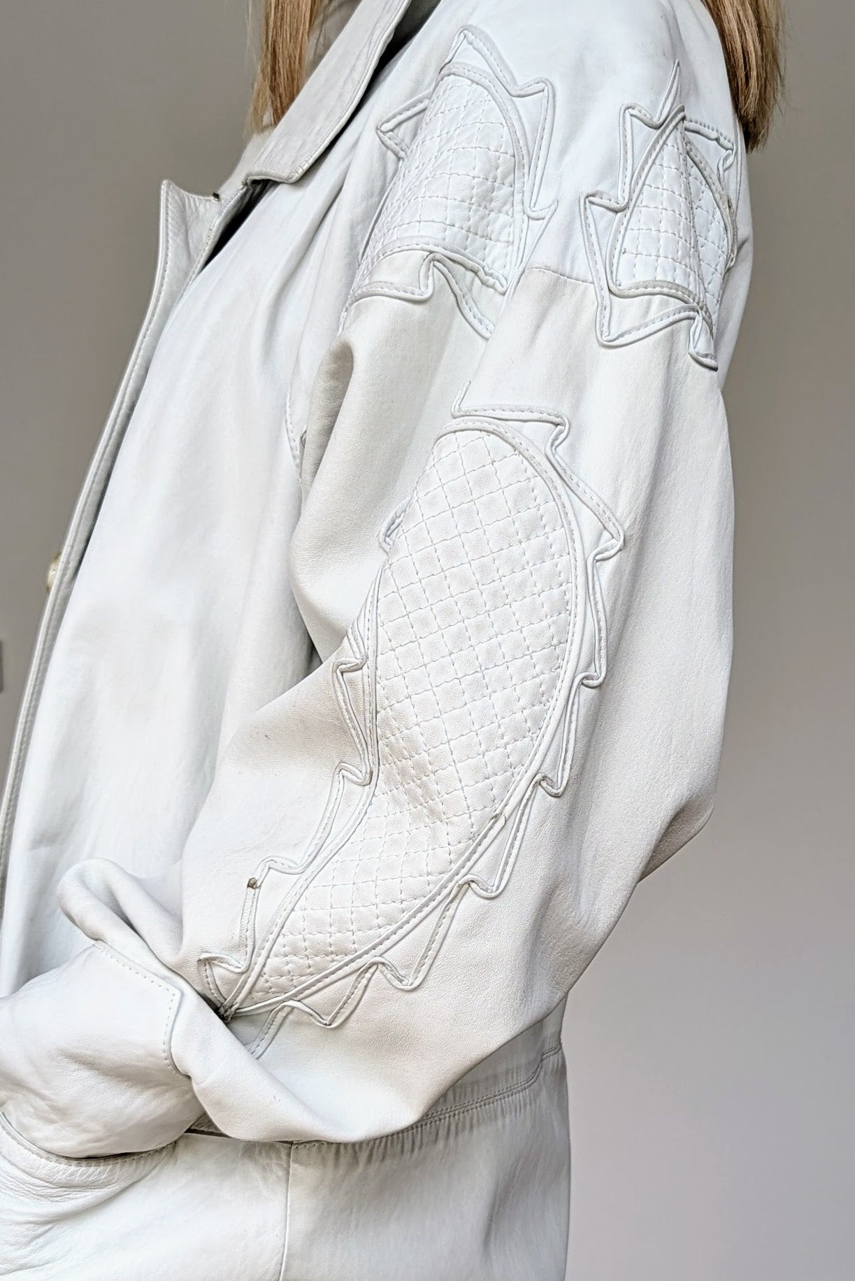 applique on arm of long applique white vintage leather coat