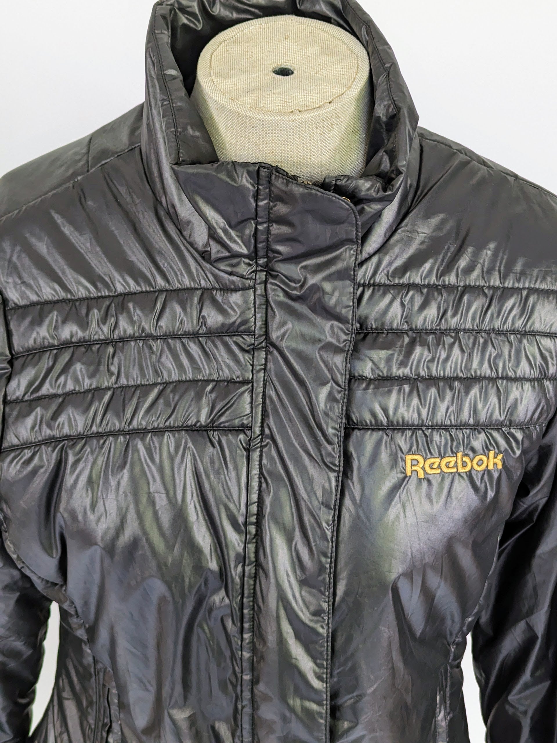 close up on top of black reebok jacket with panelled stitching to the top