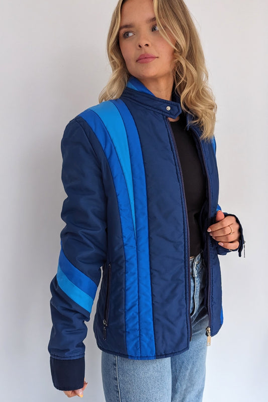 vintage blue puffer ski jacket with different tones of blue stripes on front, sleeves and neck