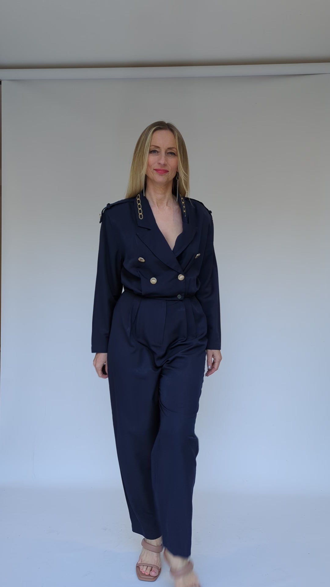 Navy jumpsuit with gold buttons and long sleeves