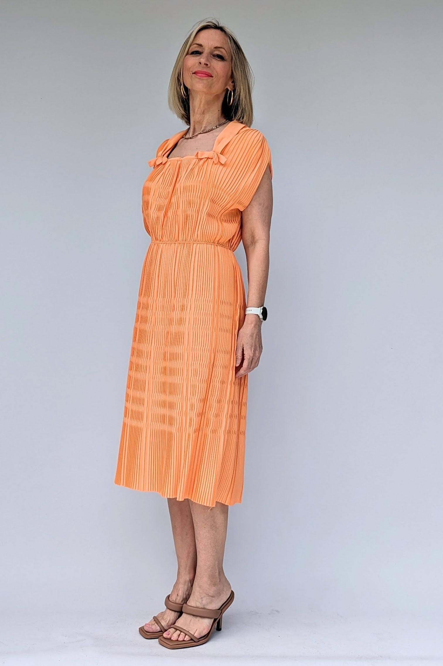 vintage pleated peach coloured midi dress from 1960s with square neck and bows from side