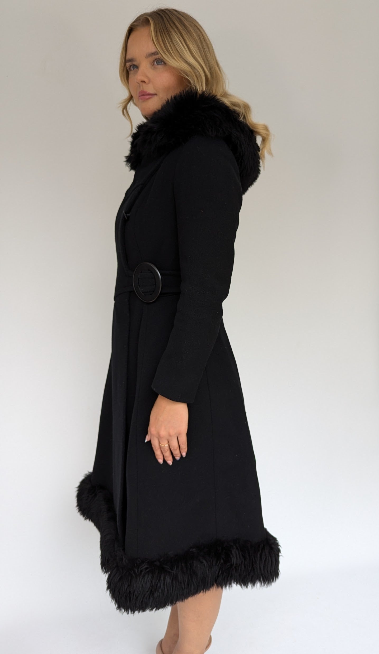 side of 60s vintage black coat by richards with fur trim to hood and bottom