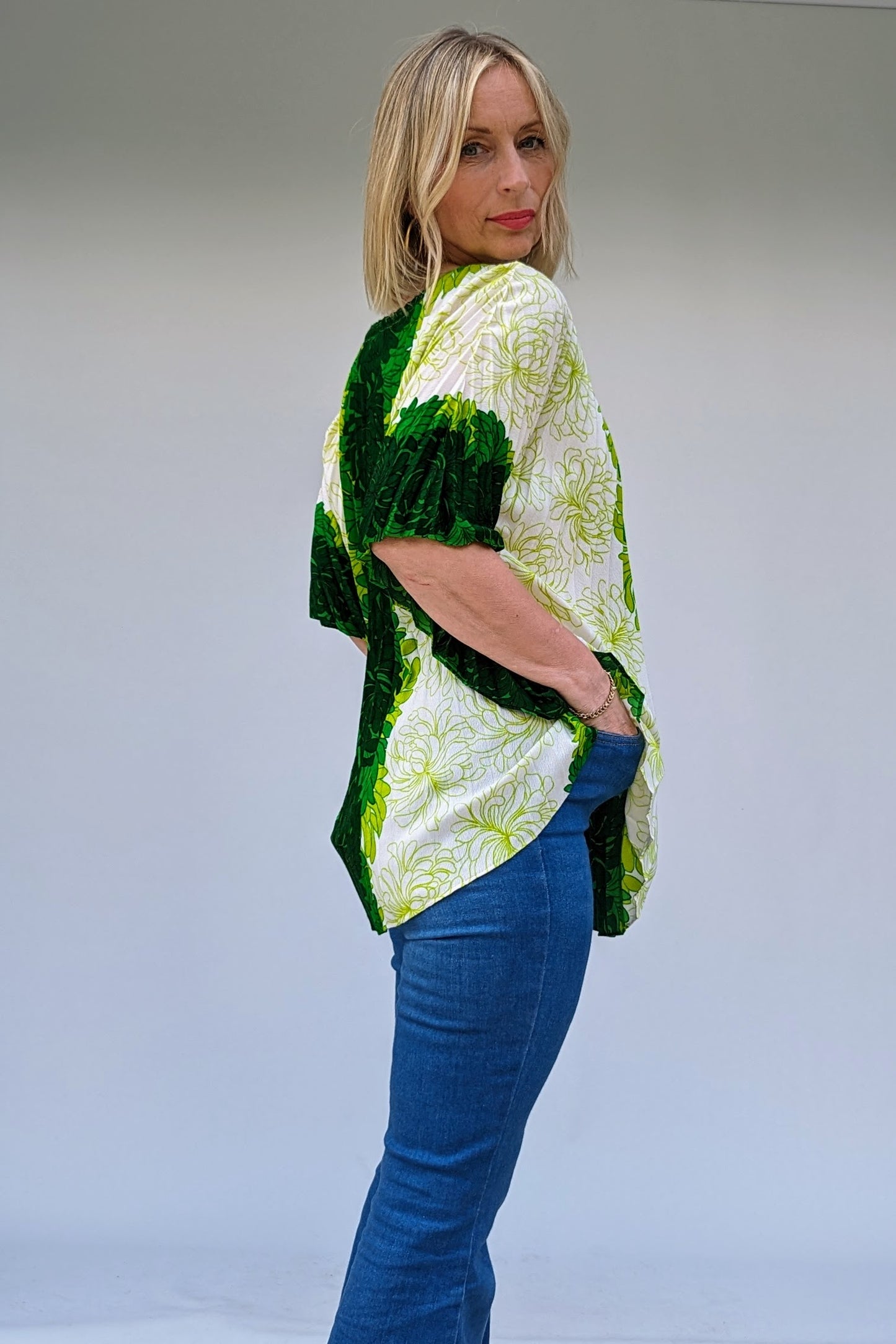 side of 1960s vintage green and white hawaiian pleated accordian summer beach ware tropical top