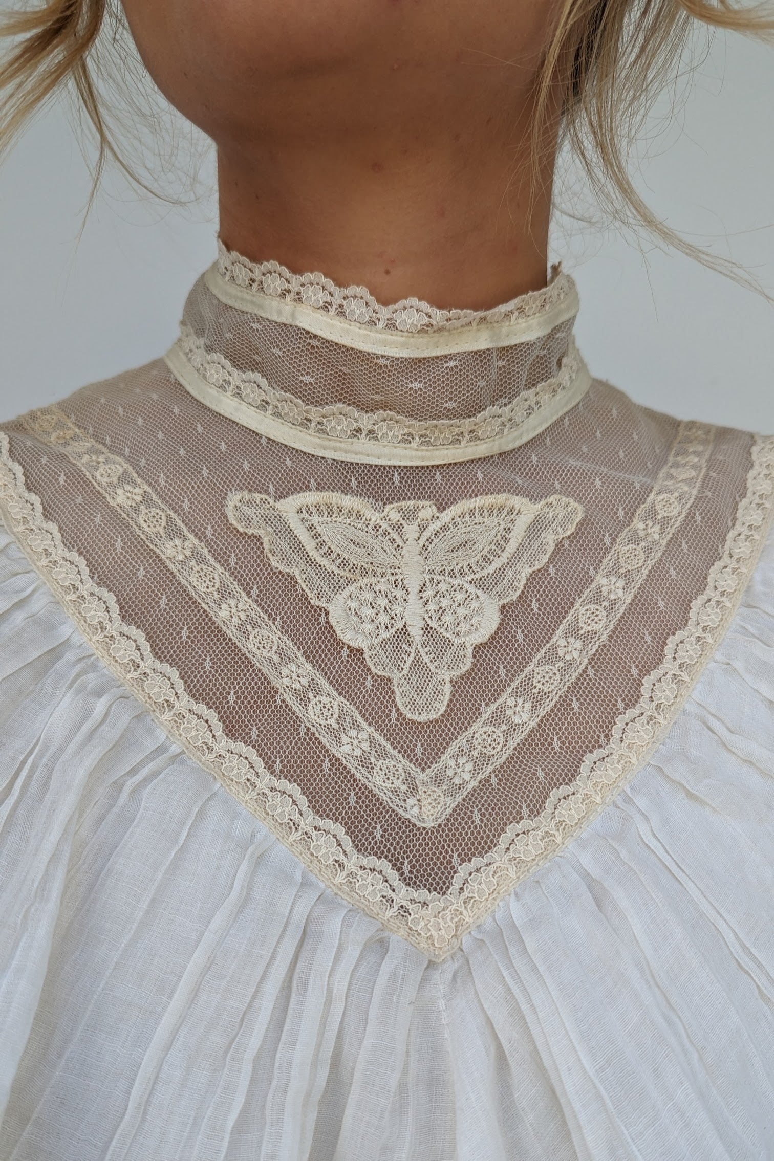 close up of lace butterfly on neckline of 70s vintage dress