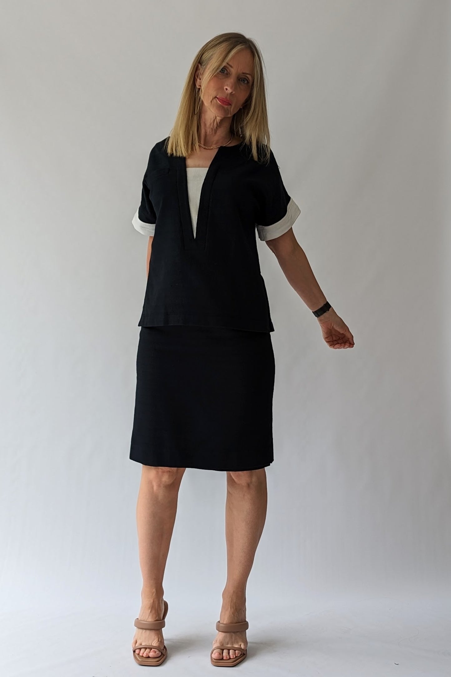 black skirt and top with white trim to sleeves and neck