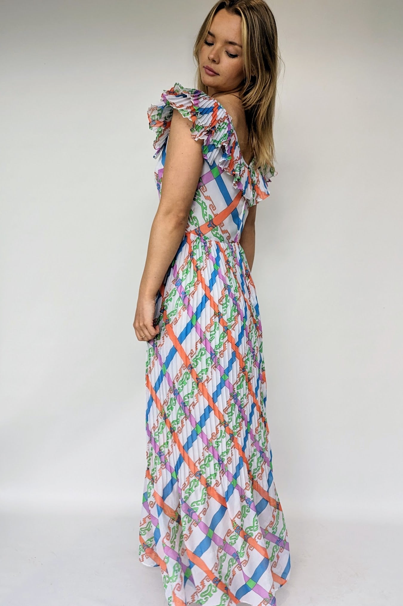 frilled neckline and side view of vintage 1970s maxi dress with bold pattern of orange, green, blue and purple