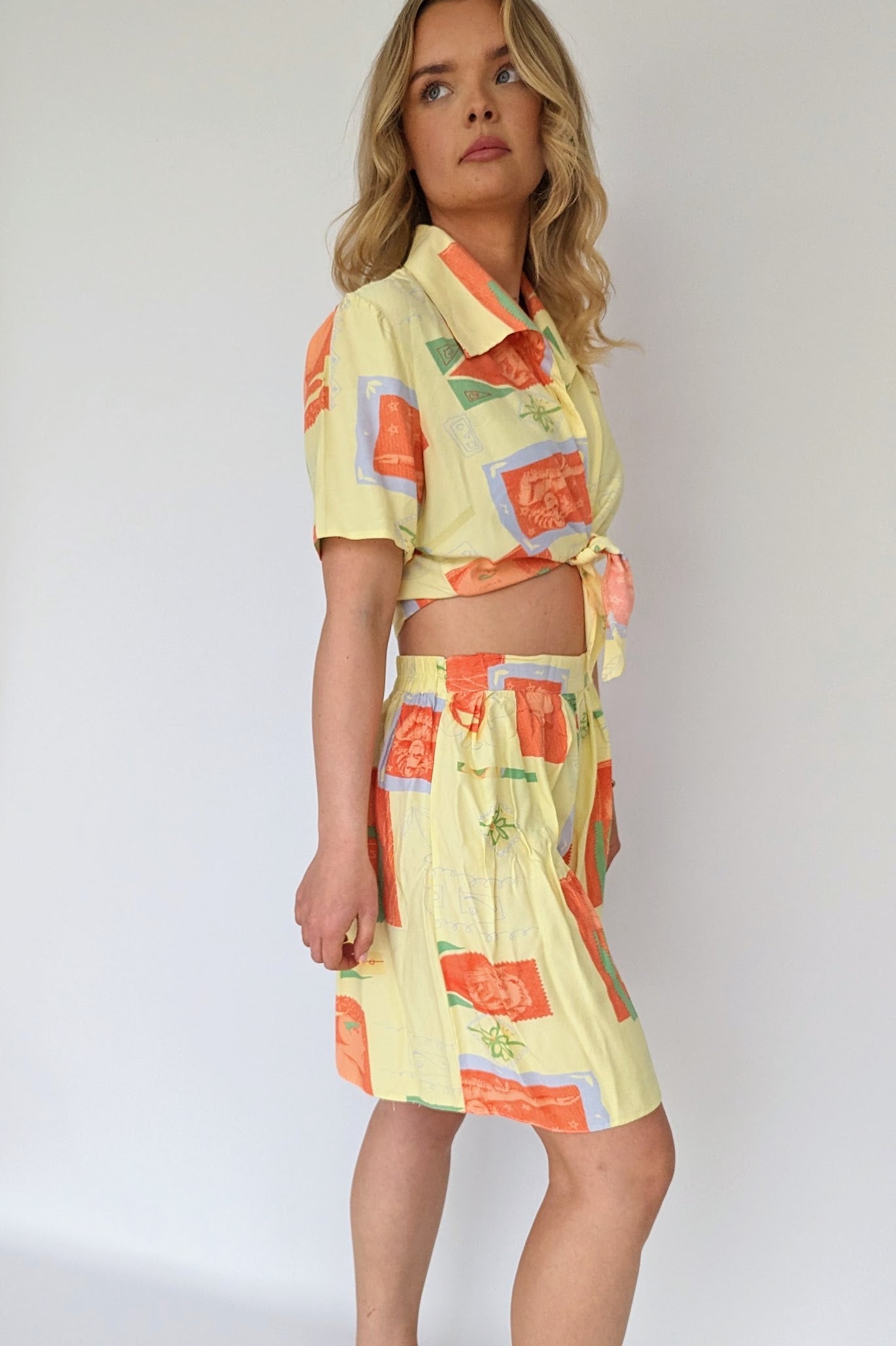 side view of vintage 80s yellow and orange co-ordinate set with shorts and a tie blouse